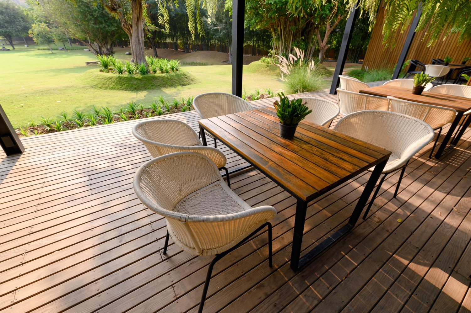 Chaise en bois avec table et flore verte sur patio